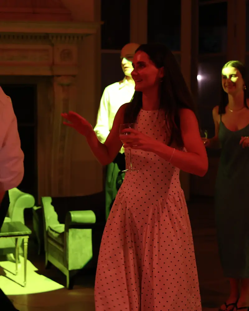 Une invitée danse en souriant sous les lumières de la soirée (photo Vally Photography)