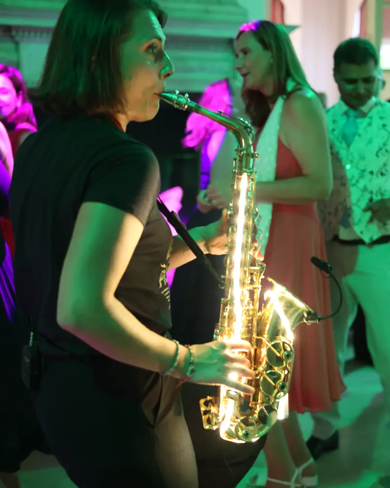 The saxophonist playing among the dancers under green light (photo by Vally Photography)