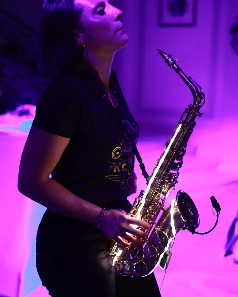 The Prestige Sound saxophonist backlit in magenta light (photo by Vally Photography)