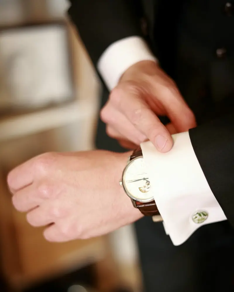 Een manchetknoop wordt vastgemaakt, een horloge om de pols (foto Vally Photography)