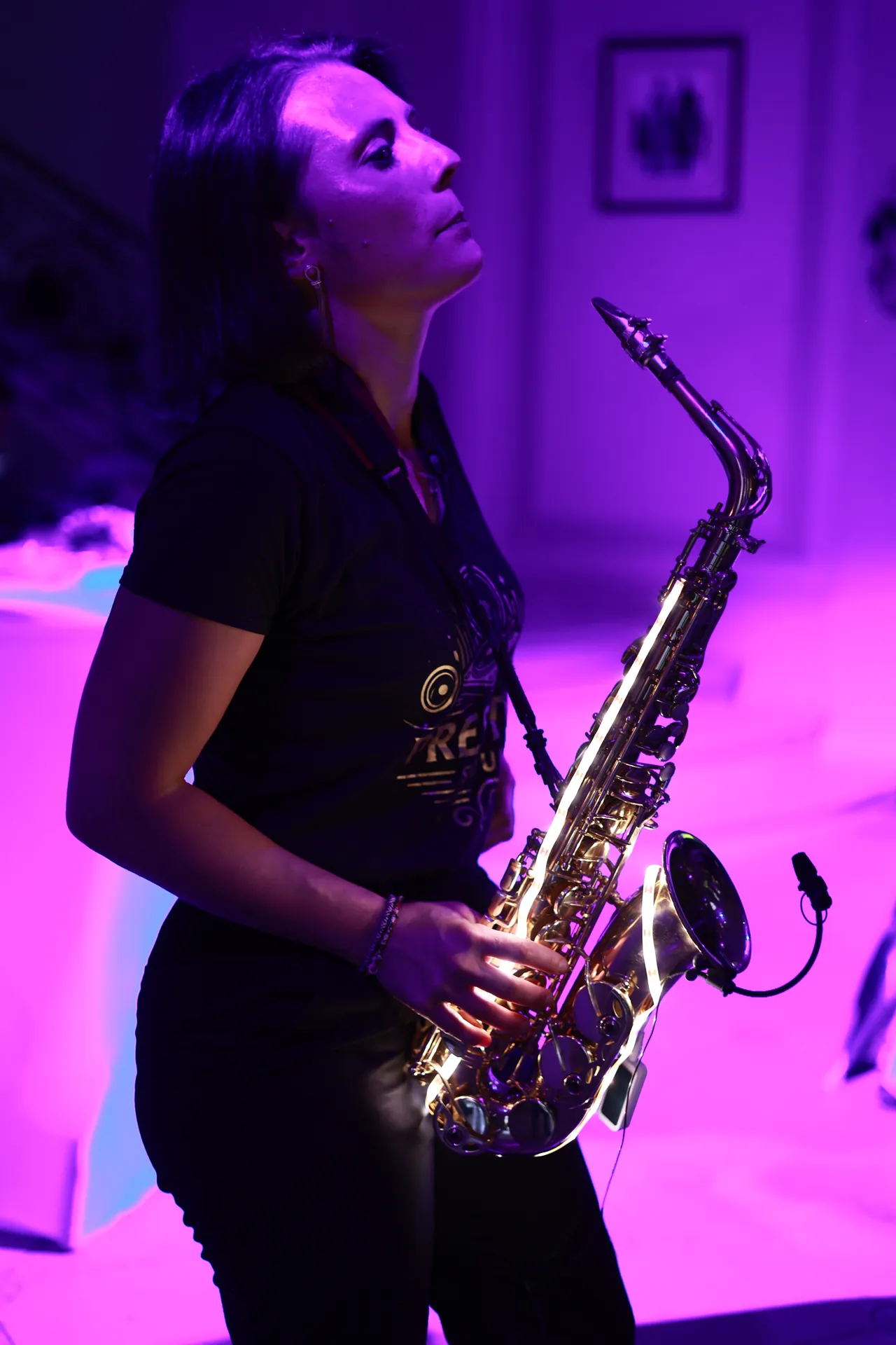 Le saxophone, tête levée dans la lumière violette