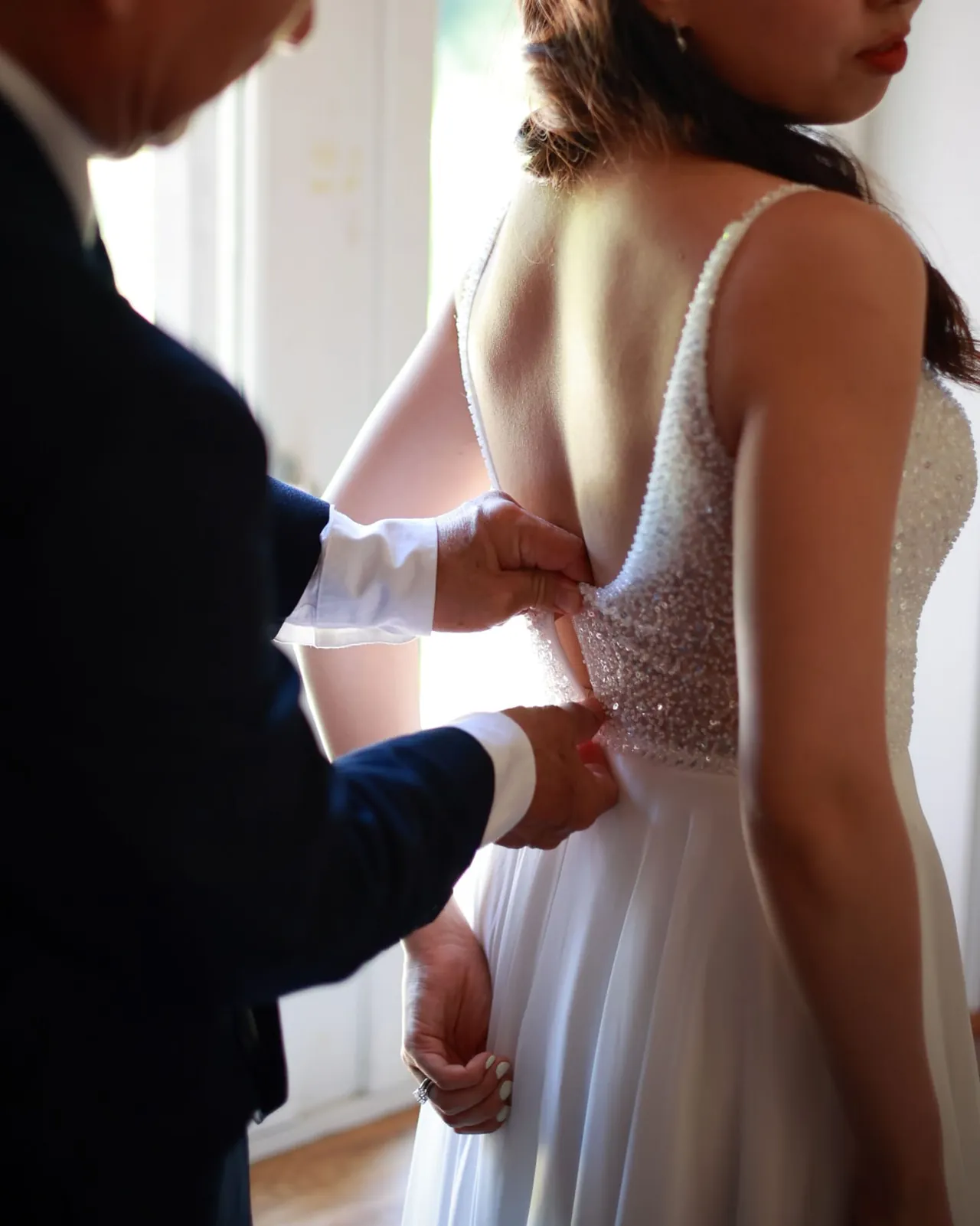 On referme le dos perlé de la robe