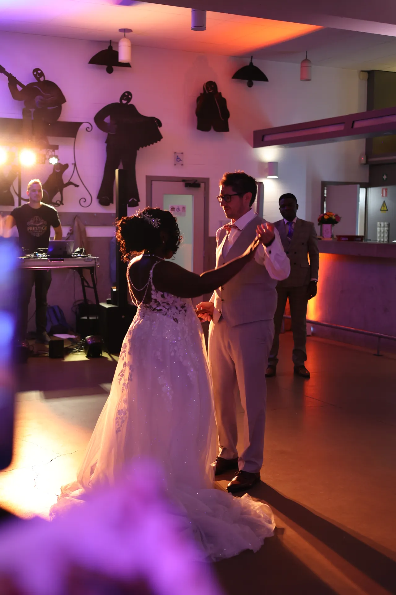 Openingsdans midden op de dansvloer, hand in hand, met de DJ aan de regie op de achtergrond