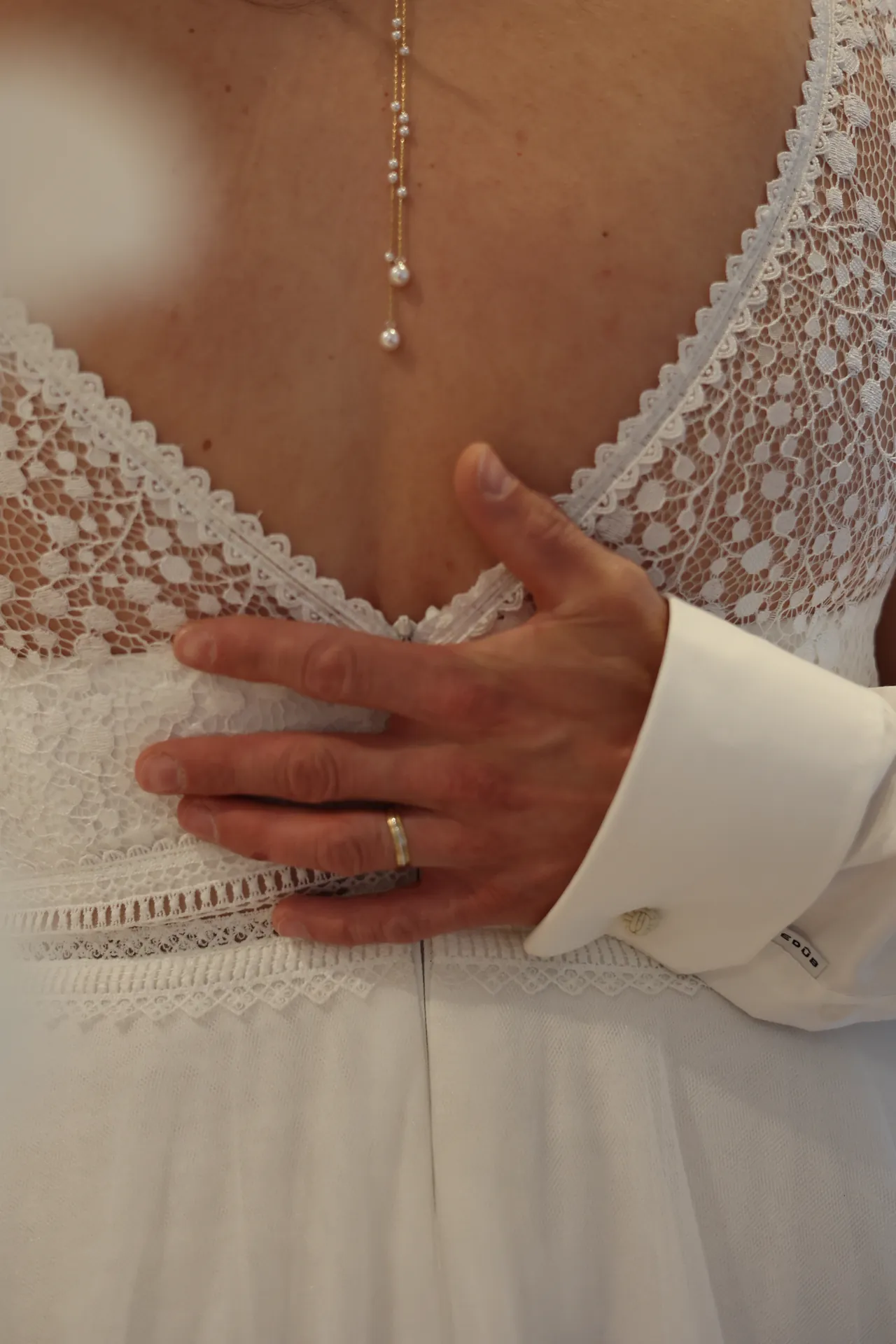 Une main alliancée posée sur le dos en dentelle
