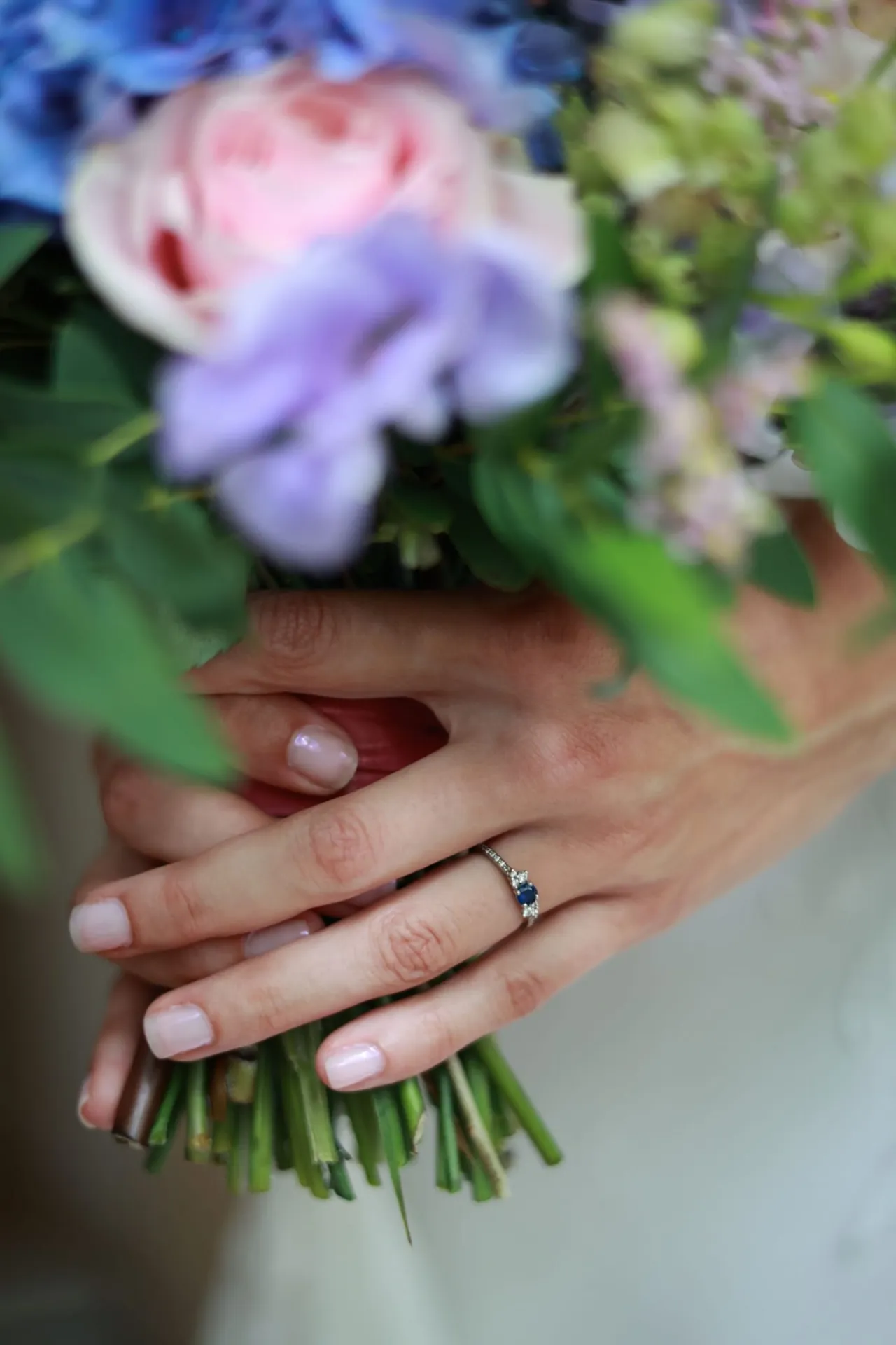 Les mains baguées tenant le bouquet