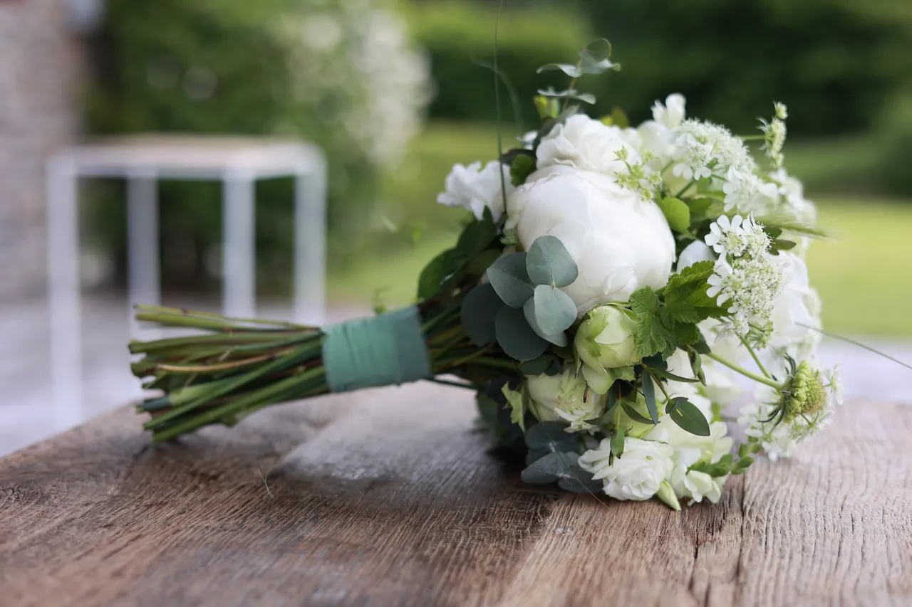 Un bouquet de pivoines blanches posé sur le bois brut