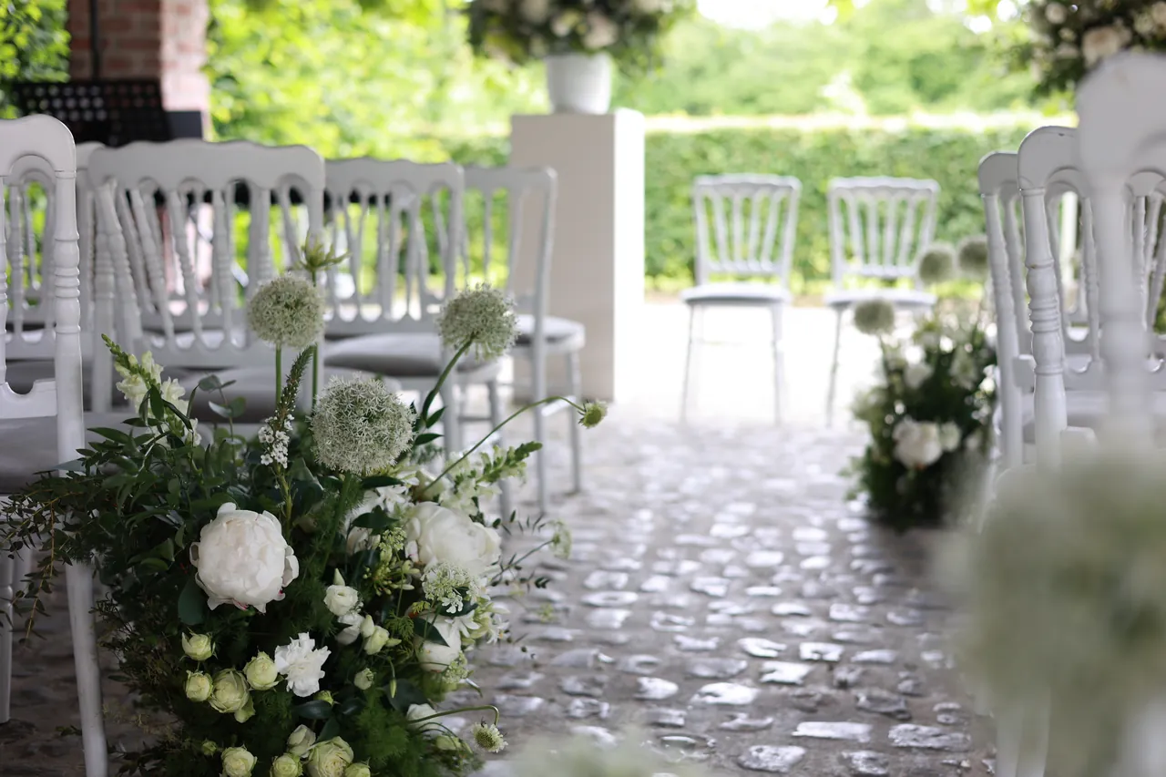 Des fleurs blanches le long de l'allée de la cérémonie