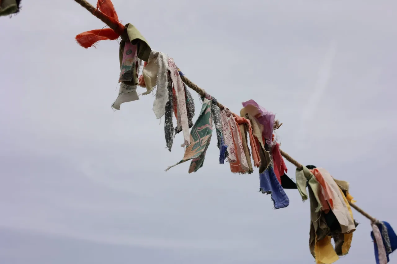 Des rubans de tissu colorés noués sur une corde