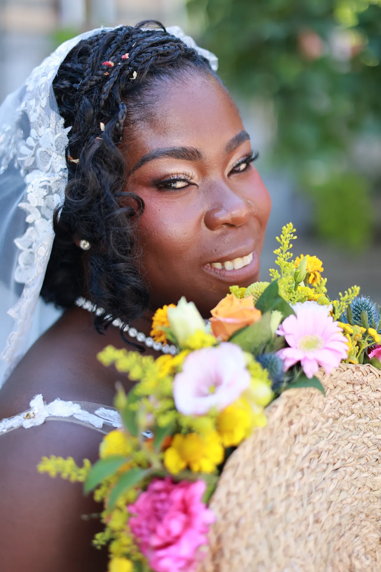 Un sourire éclatant, le bouquet de fleurs vives à l'épaule