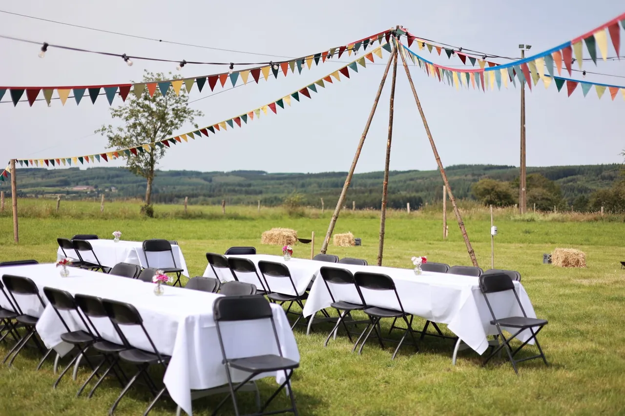 Les longues tables nappées sous les fanions