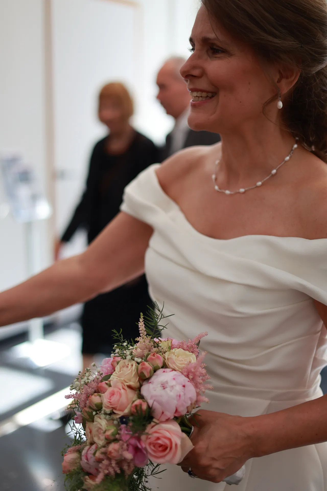 Un sourire, le bouquet de pivoines à la main