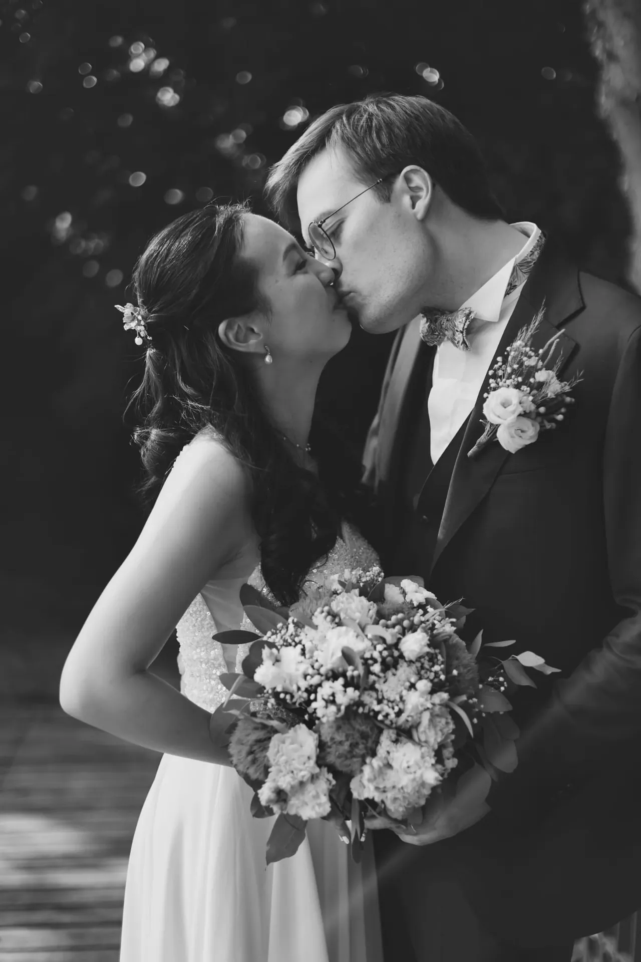Un baiser sur le pont, le bouquet serré, en noir et blanc