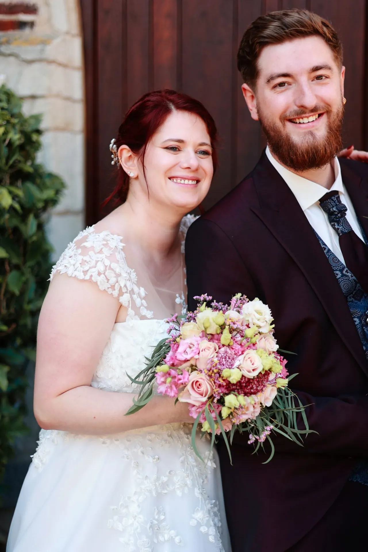 Le couple souriant devant la porte de l'église