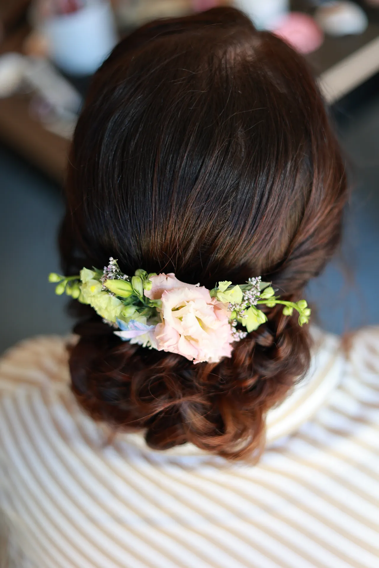 Une couronne de fleurs pastel dans un chignon tressé
