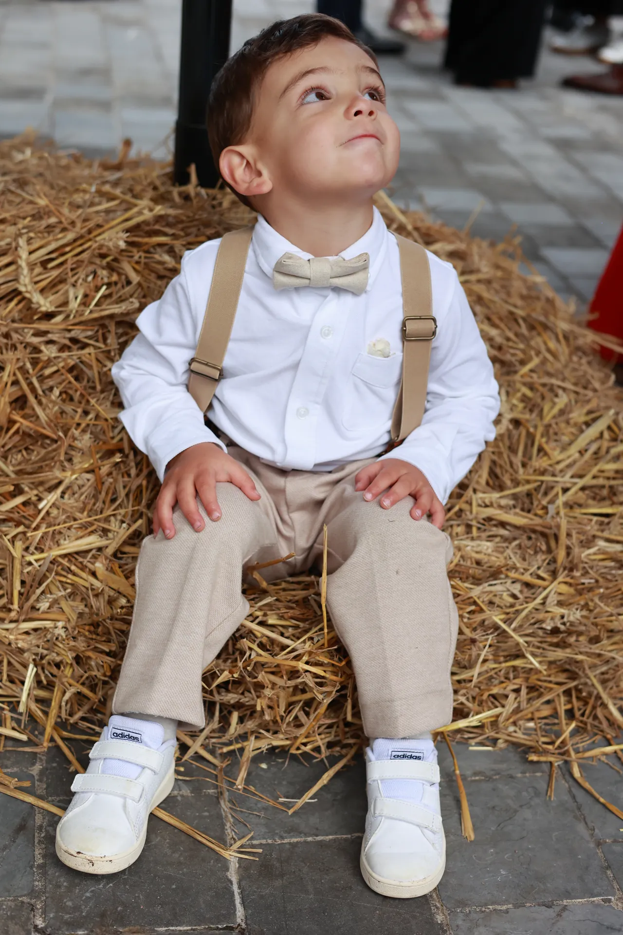 Un enfant assis sur la paille, le regard levé