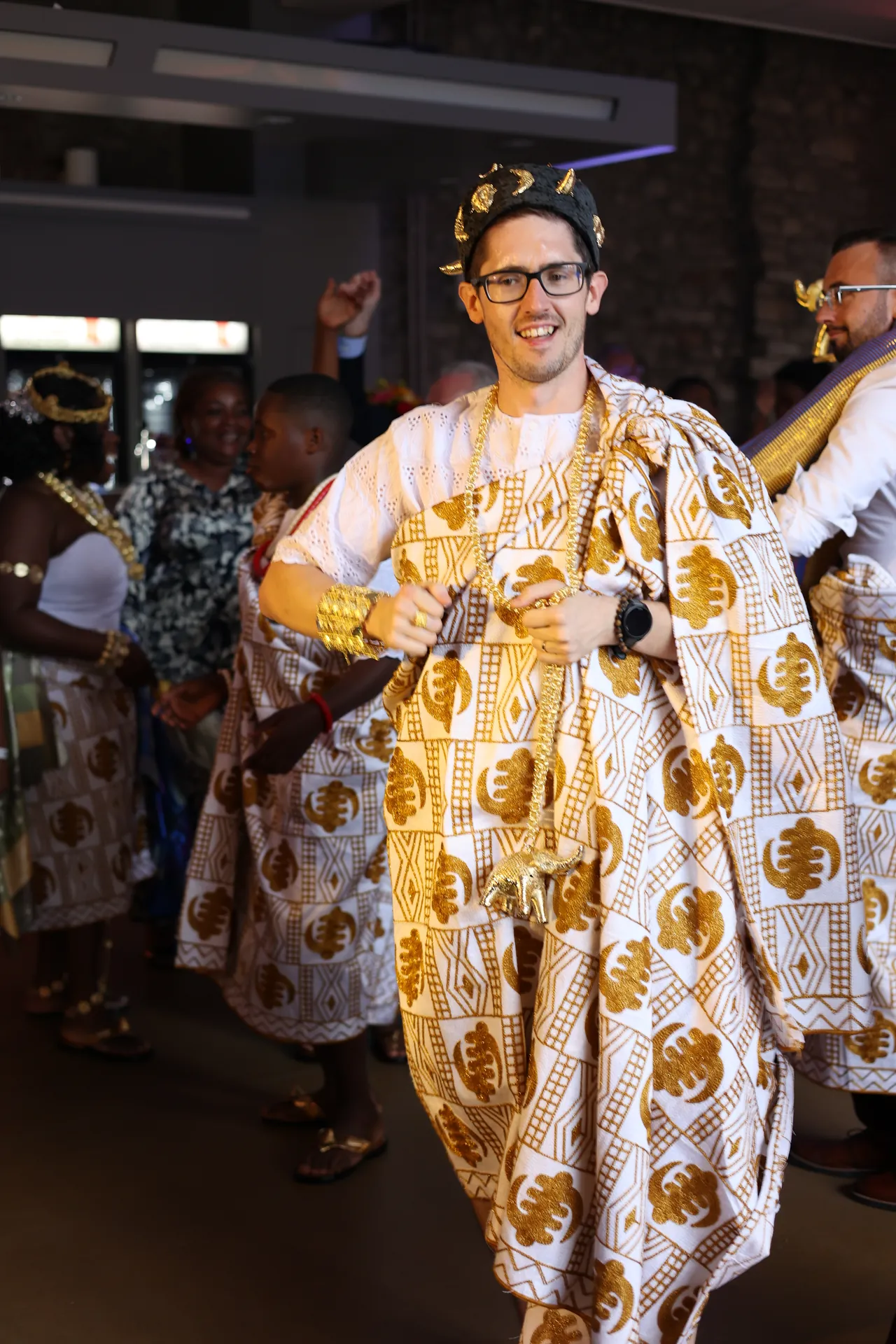 Une danse en toge traditionnelle dorée, grand sourire