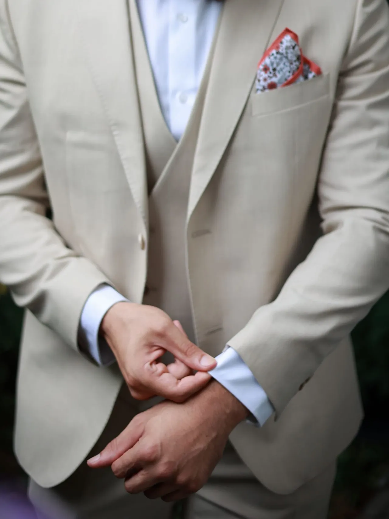 On ajuste la manchette d'un costume beige