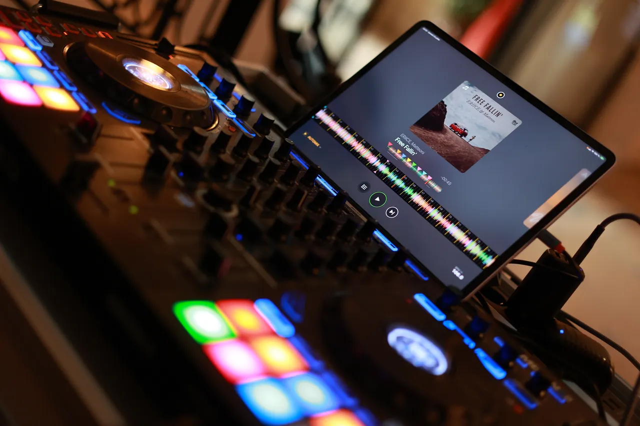 De controller met veelkleurige pads en de tablet van de DJ, midden in het feest