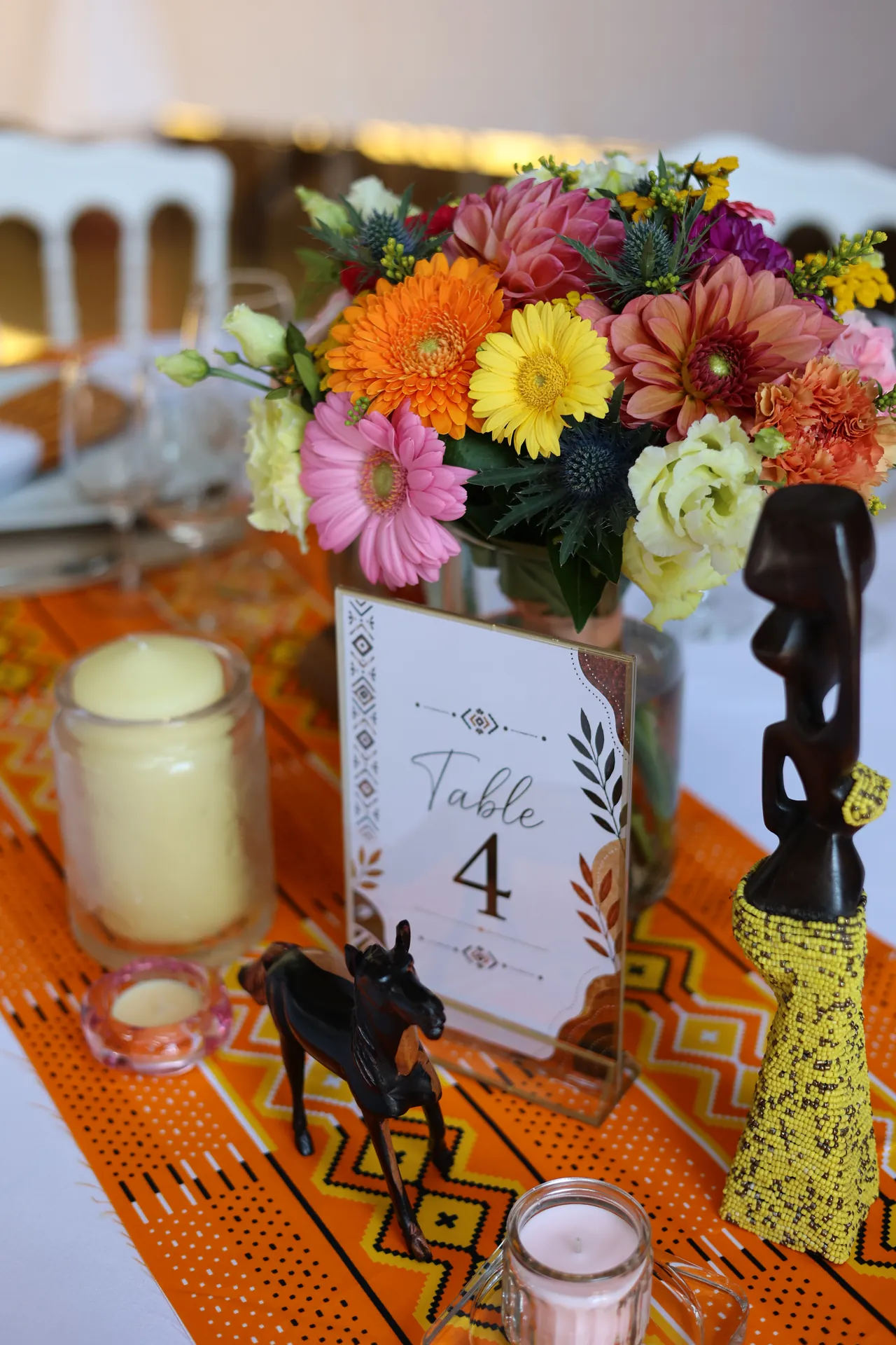Un centre de table fleuri sur un chemin en tissu wax