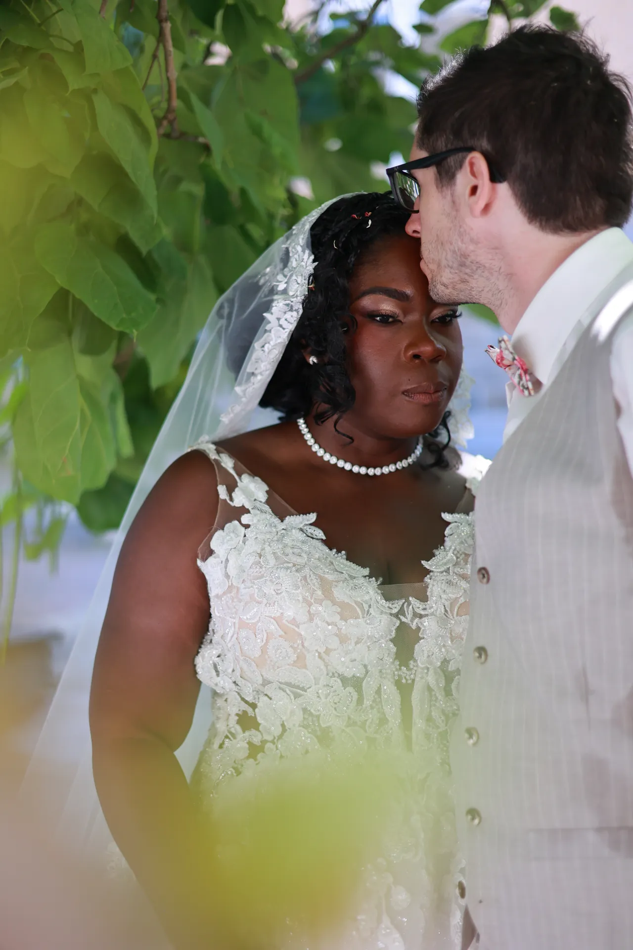 Un baiser sur le front, derrière le feuillage