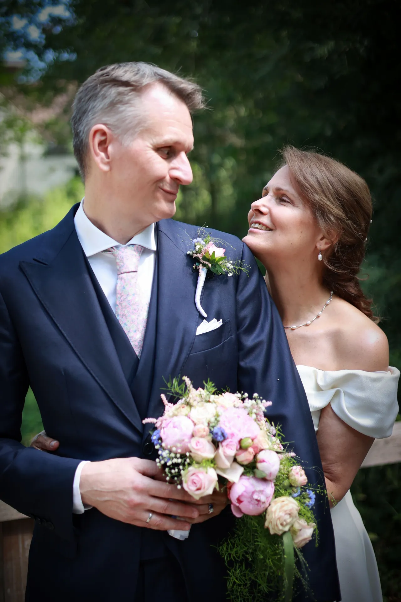 Un sourire complice, le bouquet contre soi