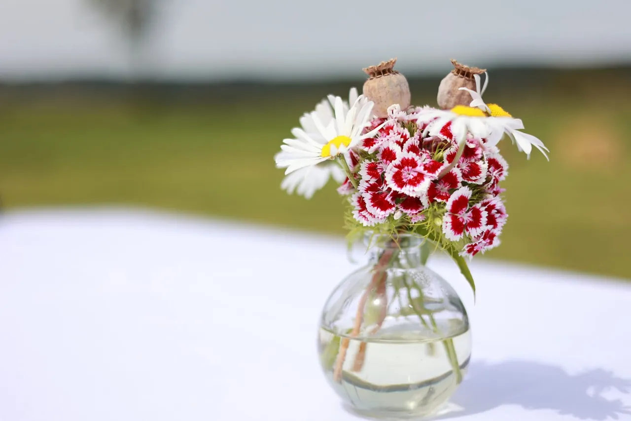Un bouquet champêtre dans un petit vase en verre