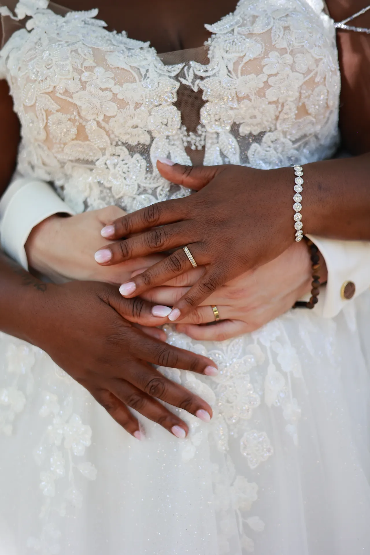 Les mains croisées sur la robe, les alliances en évidence